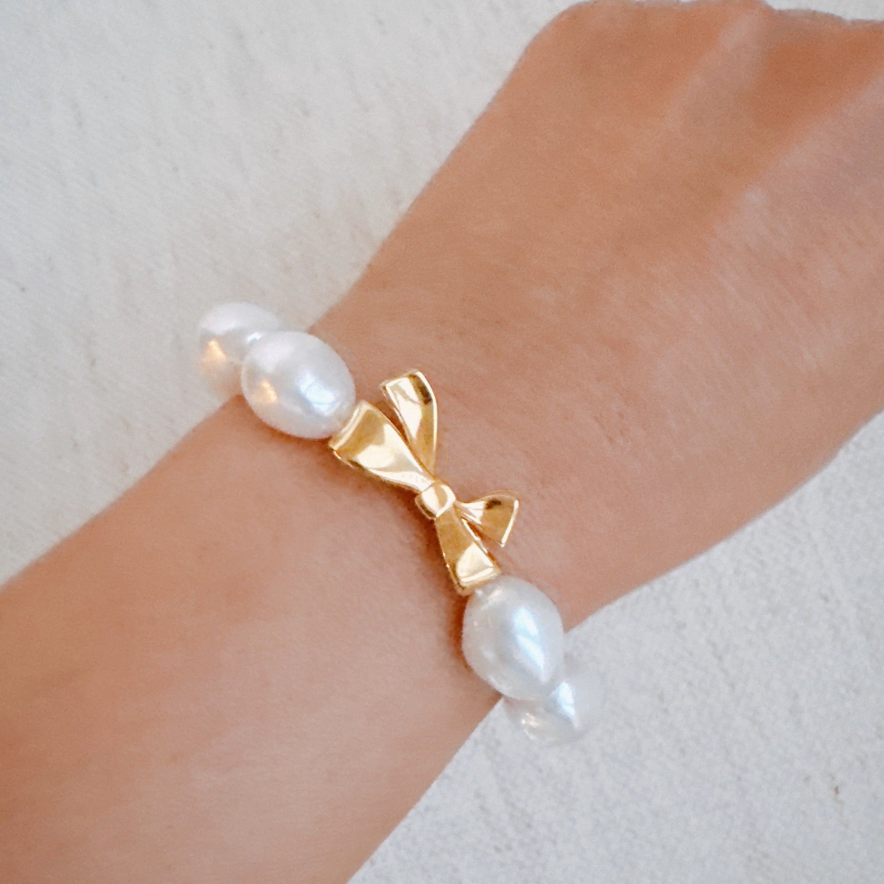 Elastisches Armband mit Goldschleife und Perlen